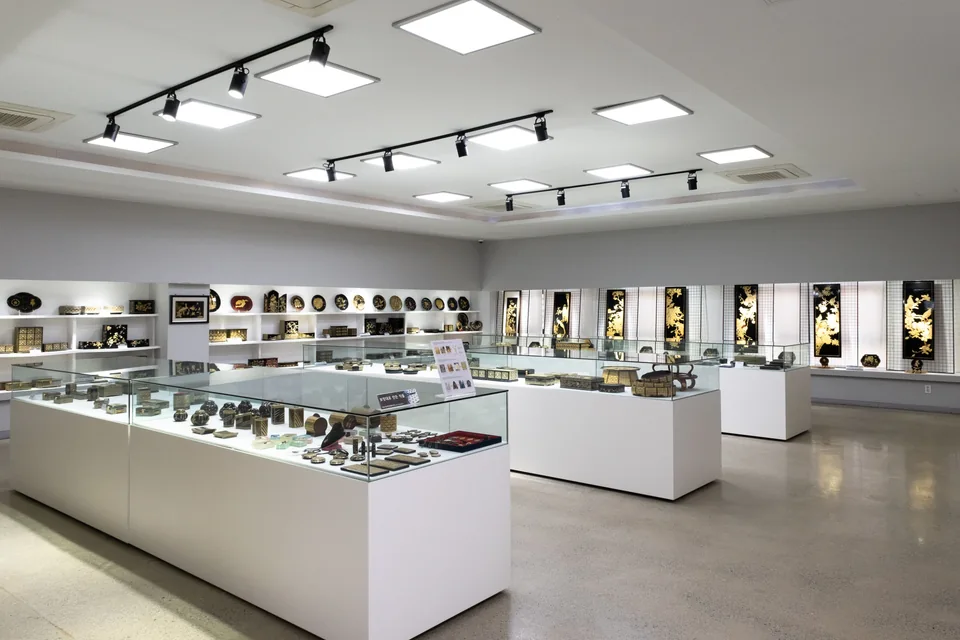 Salle d’exposition lumineuse avec plusieurs vitrines et objets décoratifs.